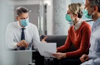 Healthcare professionals meeting with financial advisor to discuss medical business financing & low-revenue funding options.