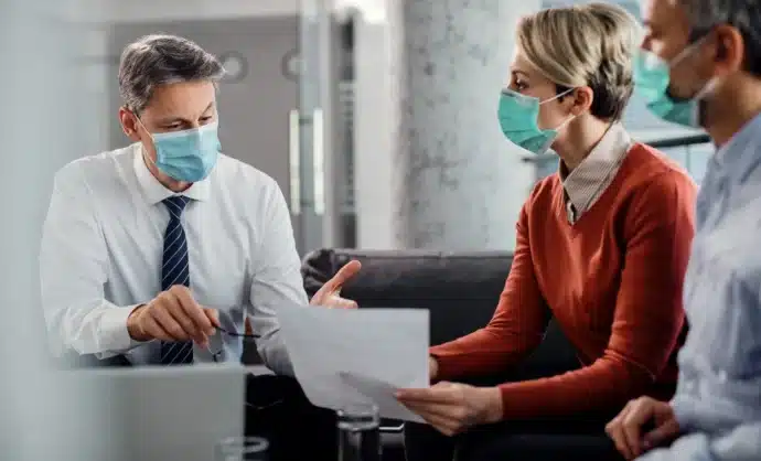 Healthcare professionals meeting with financial advisor to discuss medical business financing & low-revenue funding options.